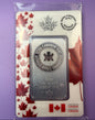 A 1 oz silver bullion bar from the Royal Canadian Mint, presented in its original plastic packaging with a white and red maple leaf card backing, set against a purple textured background.